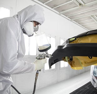 Collision Center Technician Painting a Vehicle | Acton Toyota of Littleton in Littleton MA